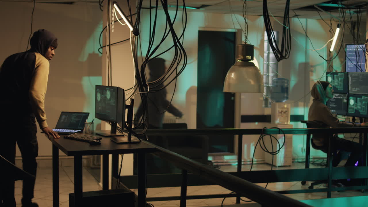 Hackers Working on Computers in Dark Room