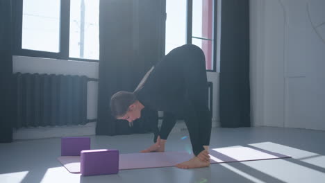 mujer haciendo postura de yoga en el estudio