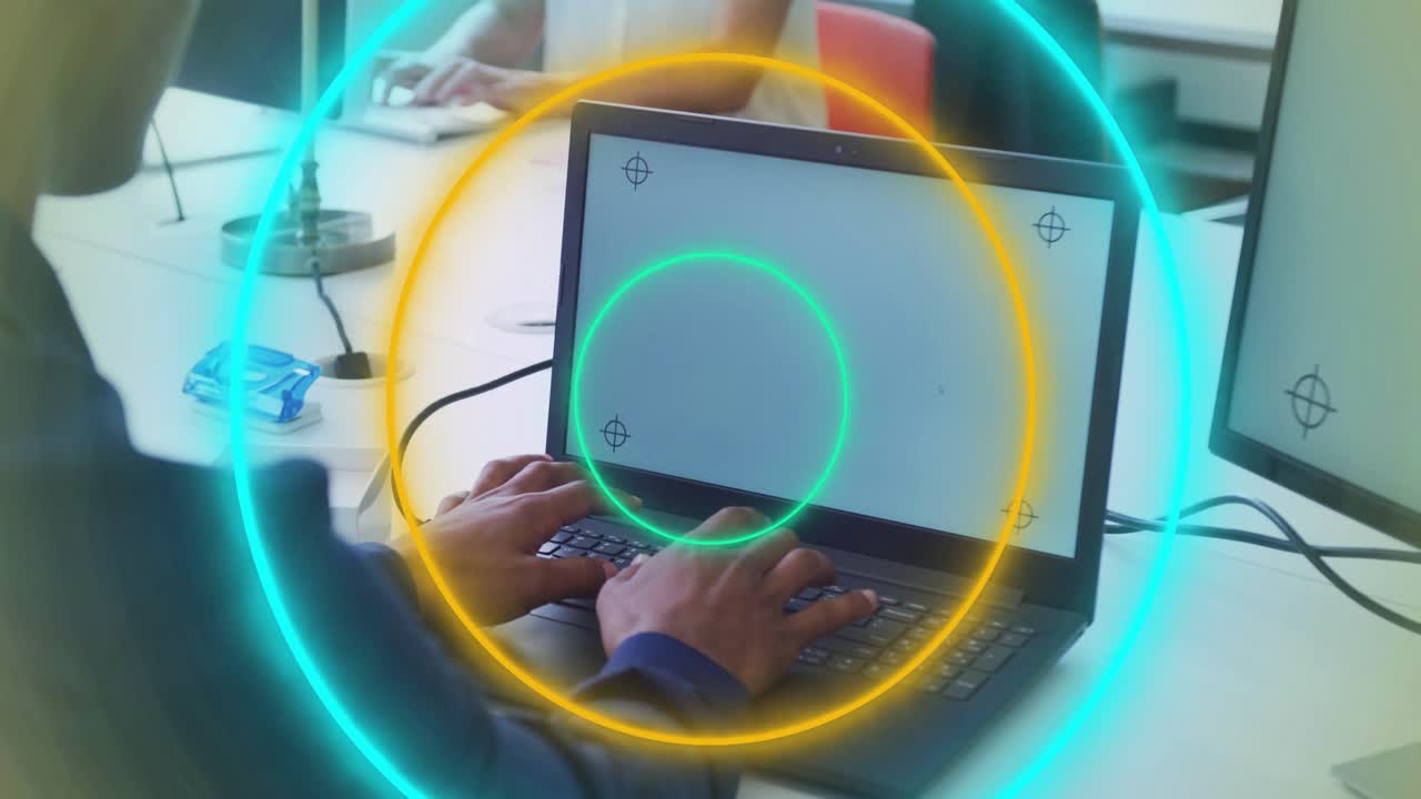 Man typing on laptop, initiating animated neon rings highlighting crosshairs for tech demo