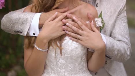 slow motion shot of groom and bride hugging and showing wedding rings, camera floating shot