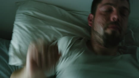 man with insomnia lying in bed at night