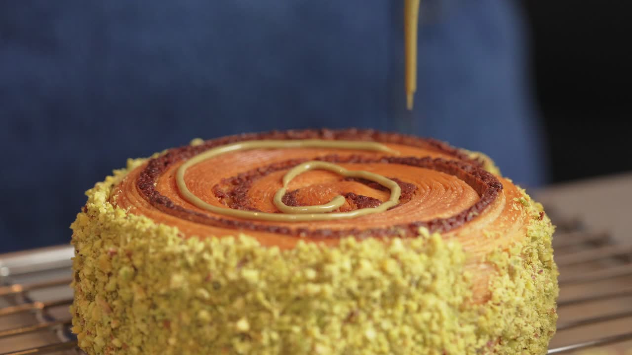 Fıstıklı donut, iç dolgusu eklenerek süsleniyor, yandan görünüm.