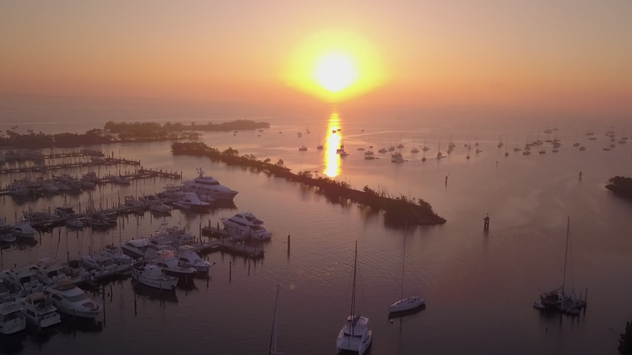 일출에서 멀리 보트 가득 항구 위로 공중 높은 각도 비행
