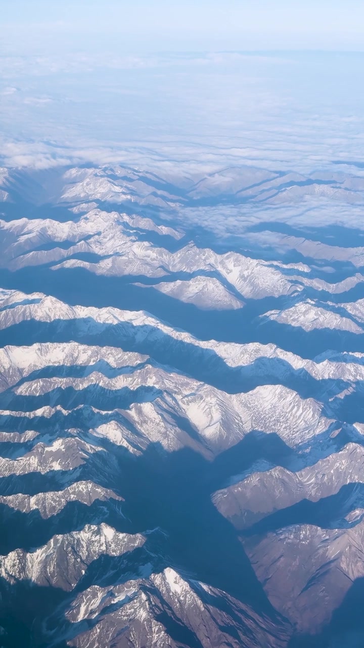空撮映像が澄み切った空の下、雪に覆われた山脈を捉え、ニュージーランドの自然の美しさを際立たせています。