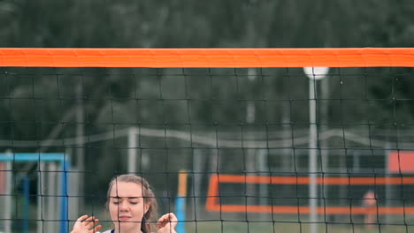 mujeres compitiendo en un torneo profesional de voleibol de playa. un defensor intenta detener un tiro durante el voleibol internacional profesional de playa de 2 mujeres.