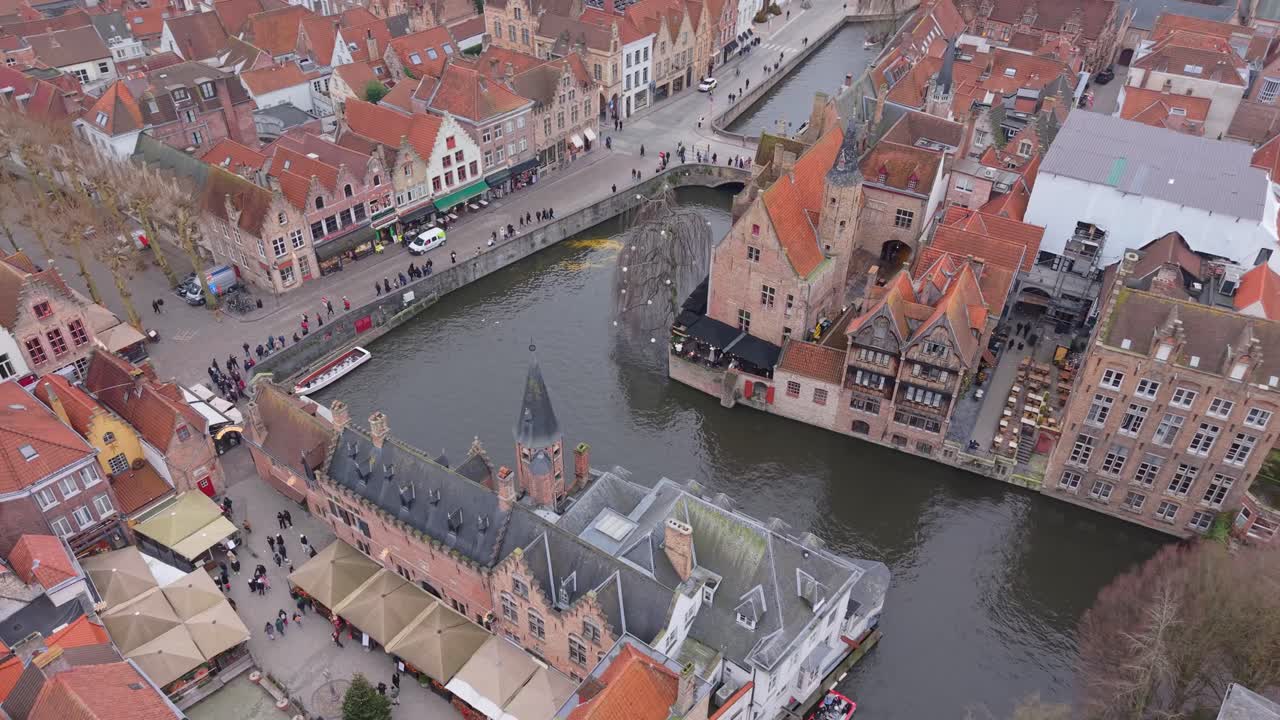 Ripresa aerea con drone di Rozenhoedkaai a Bruges, Belgio, che mette in risalto gli iconici tetti fiamminghi triangolari e lo storico canale. Una vista dettagliata dell'architettura urbana medievale.