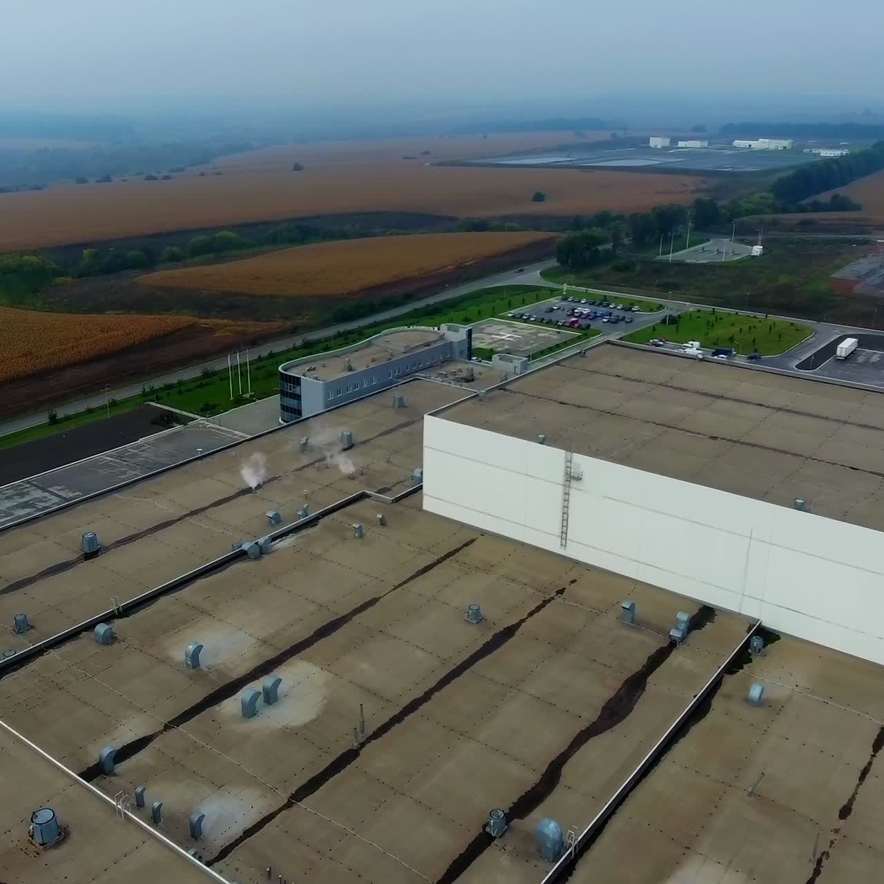 Modern big plant in green field. Huge industrial territory from above