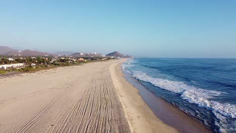 Vacation-properties-along-wide-sandy-beach-with-waves-crashing-in-Mexico