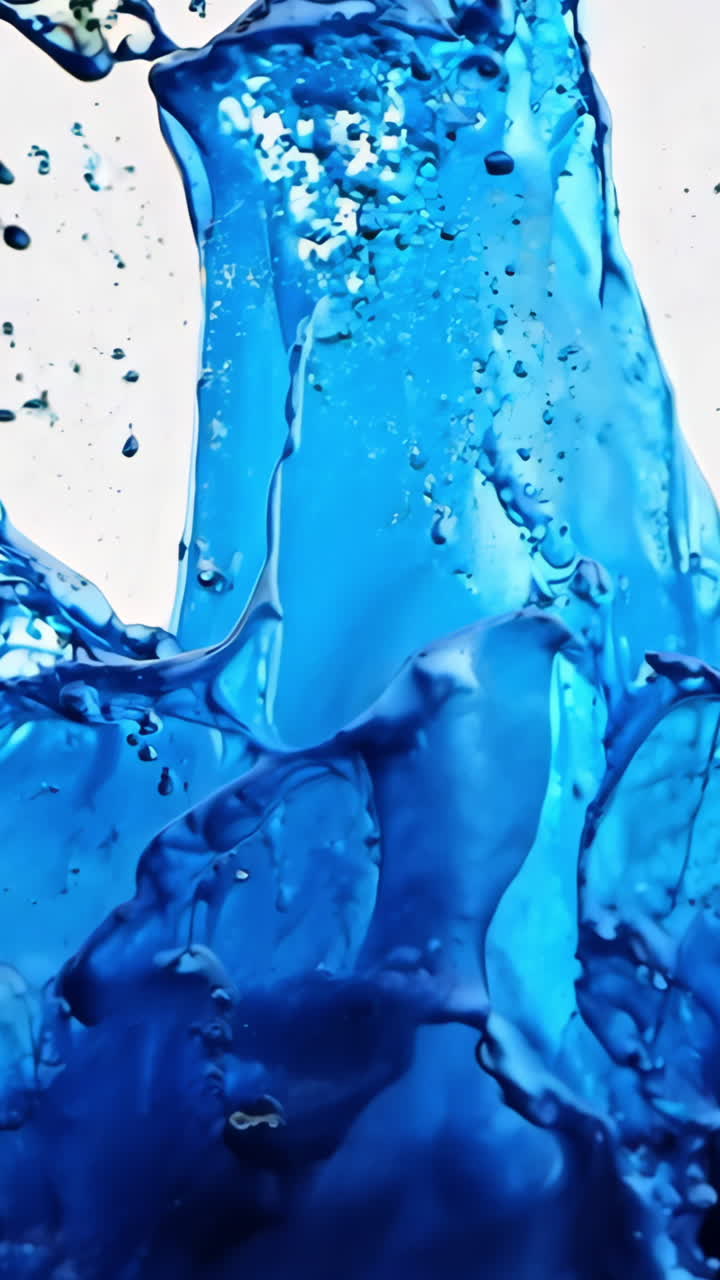 A splash of blue paint on a white background. The splash is large and covers a significant portion of the background. The blue paint appears to be splattered, giving the impression of movement