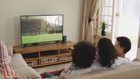 composite of happy family sitting at home together watching hockey match on tv