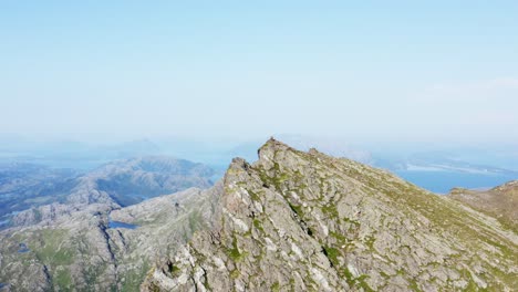 rocky peak of mount donnamannen with bright blue sky in norway