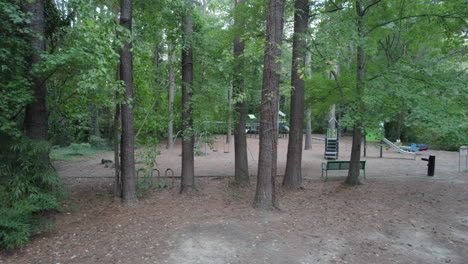 Aerial-Truck-shot-of-a-empty-playground,-surrounded-by-lush-trees