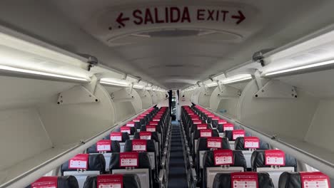 inner view of an empty jet passenger cockpit from behind