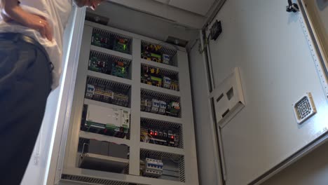 gabinete de control electrónico de apertura del capitán para puertas herméticas a bordo del barco - clip estático de ángulo bajo mirando hacia arriba y dentro del gabinete con electrónica