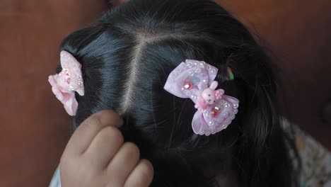 a little girl with pink bows in her hair