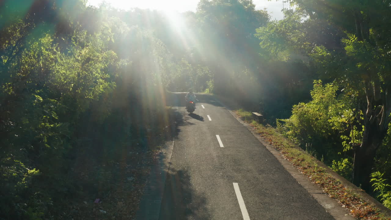 사람들의 항공 영상이 누사 페니다 섬에서 오토바이를 운전하고 있습니다.