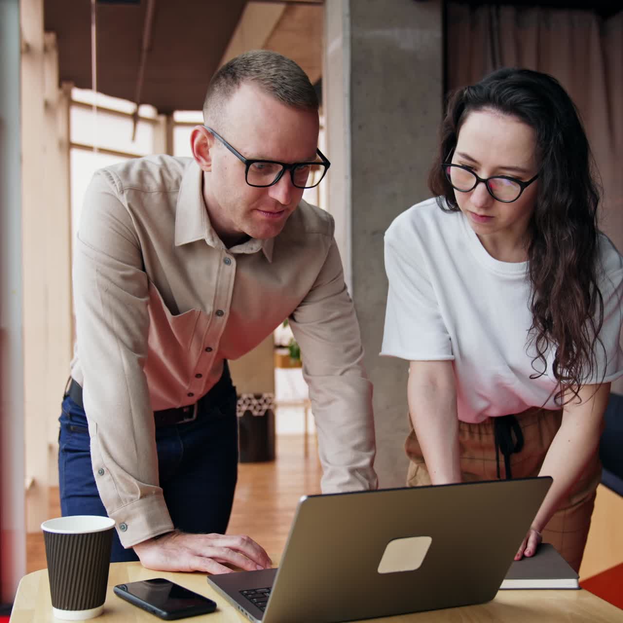 Solving problems at work. Male and female colleagues bent over the laptop, talk searching the solution