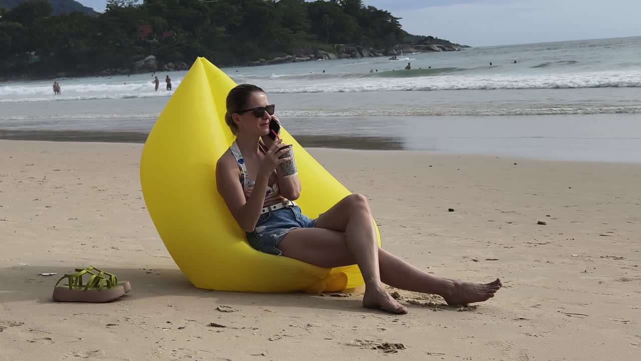 Woman relaxing on a beach in a yellow inflatable chair