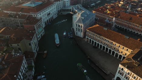 ponte rialto crossing grand canal in venice, italy - aerial drone shot