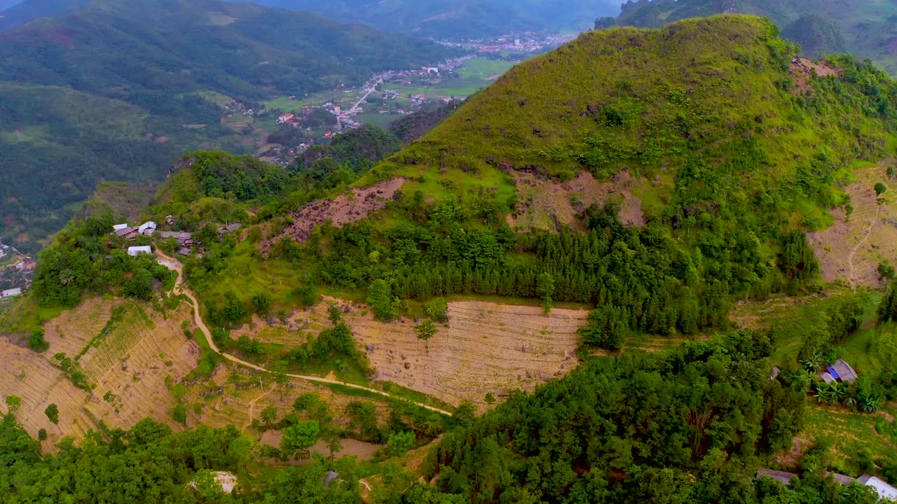 toma aérea sobre la cima de una montaña que revela una cordillera humeante en la distancia