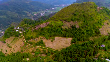 aerial shot over a mountain top revealing a smokey mountain range in the distance