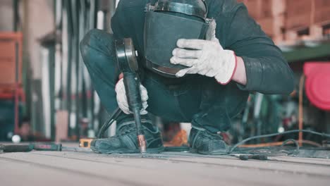 Trabajador-Mecánico-Soldador-Trabajando-Y-Sigue-Soldando-Casco-Protector-En-La-Cabeza