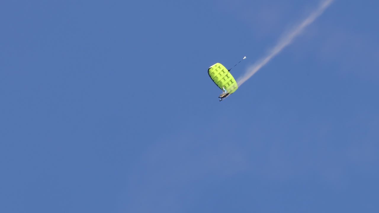 paracaidistas realizan maniobras aéreas bajo paracaídas
