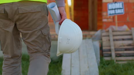 Real-estate-foreman-designer-building-project-architect-with-helmet-walking-to-construction-site