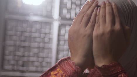 studio head and shoulders portrait of muslim woman wearing hijab praying in mosque or at home 2