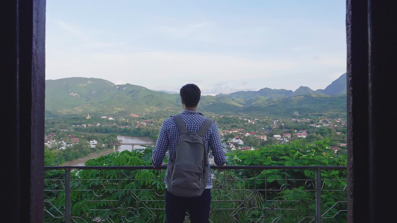 Man Looking at Scenic View from a Balcony