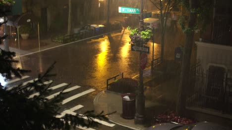 medium wide: downpour at night on beekman place, new york city.