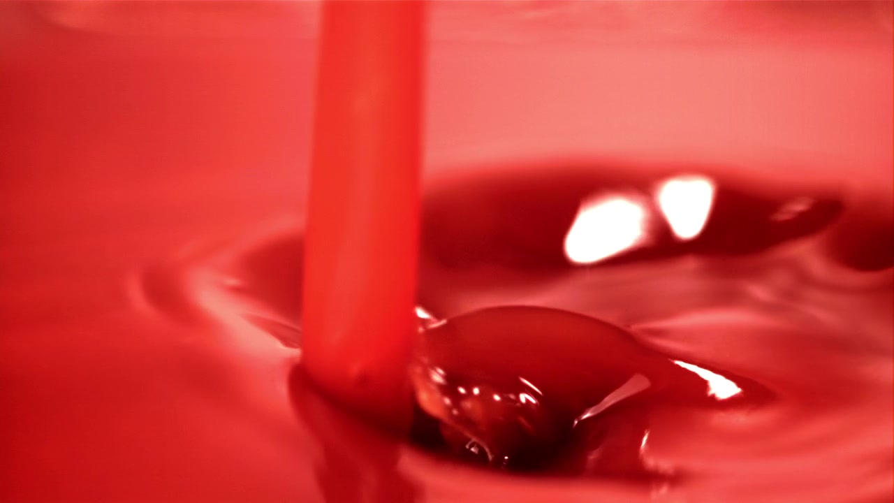Vibrant Red Fluid Pouring and Creating Ripples