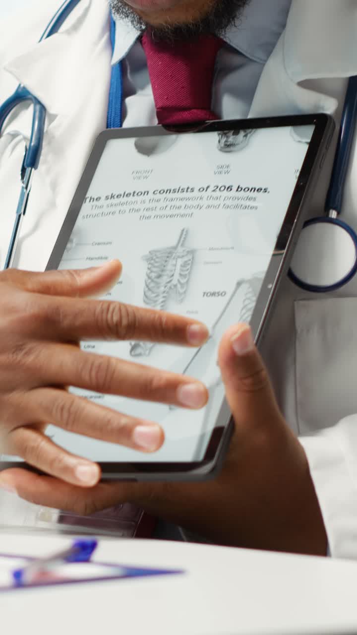 Doctor Scrolling Through Human Skeleton Diagram on Tablet