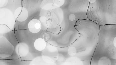 animation of white spots over grey liquid background