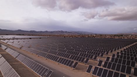 Aerial-Drone-Footage-of-Solar-Panel-Field-in-Joshua-Tree-National-Park-on-a-Sunny-Day,-fast-moving-shot-forward