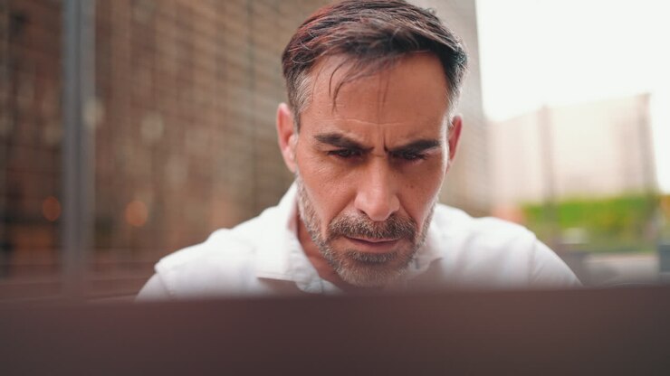 A man using a computer with different emotions