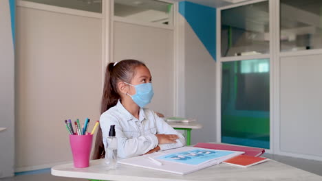 female teacher measures the little girl temperature with infrared thermometer. check for fever and coronavirus symptoms. covid-19 pandemic. back to school.