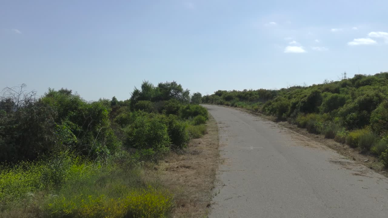 드론이 버려진 시골 도로 위로 올라갑니다.