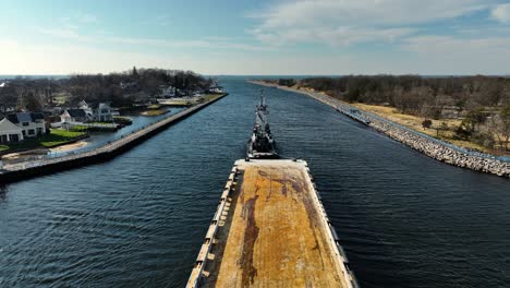 a tugboat pulling a barge and headed out to the great lake