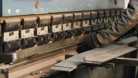 worker puts a metal workpiece in a machine