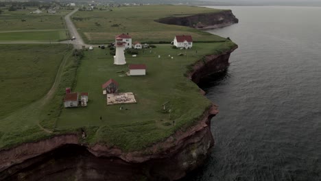 Faro-De-Cap-sante-Situado-En-La-Pradera-Verde-Con-El-Río-San-Lorenzo-Durante-El-Día-En-Quebec,-Canadá