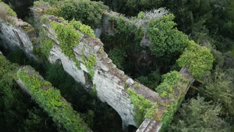 closeup aerial orbit around monastery ruins overgrown with vegetation in spain