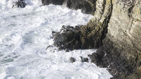 turbulent ocean waves against cliff slow motion