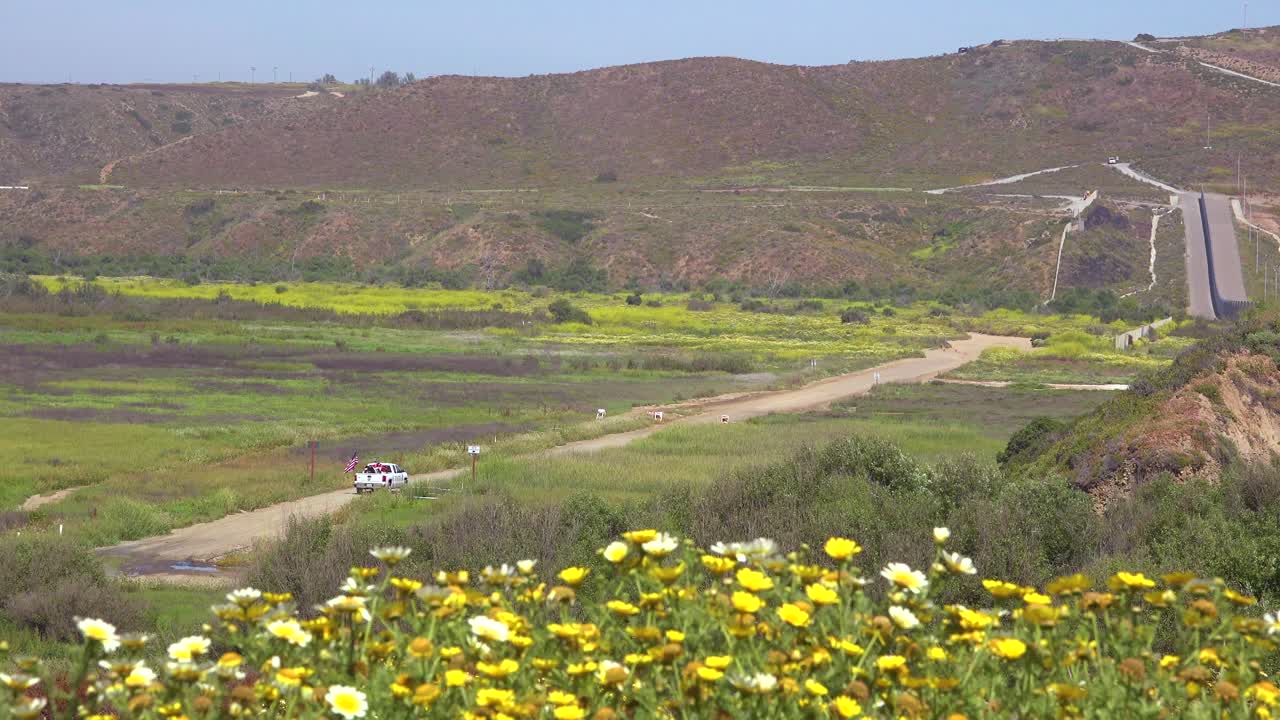 미국 미닛맨이 깃발과 픽업 트럭을 들고 미국 멕시코 국경을 따라 운전합니다.