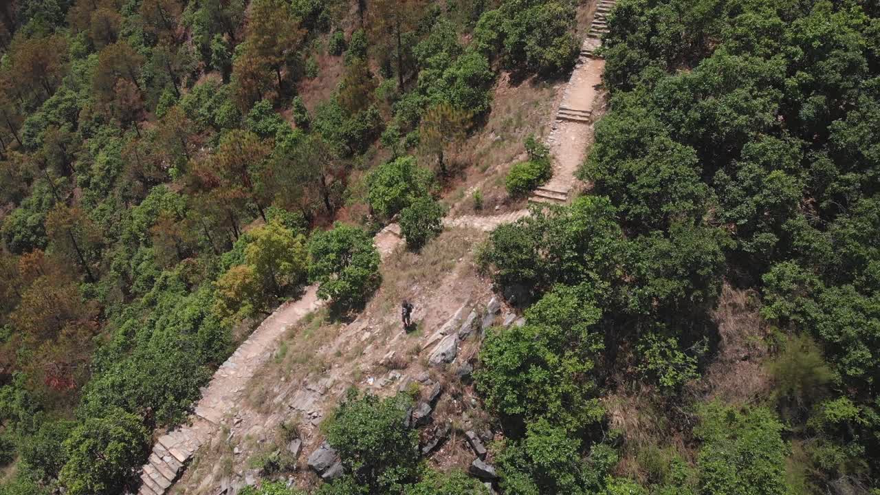 toma aérea reveladora de un dron de un joven que disfruta de la vista desde una ruta de senderismo en katmandú, nepal