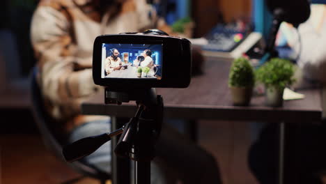 podcast host using smartphone on tripod to record guest telling interesting story