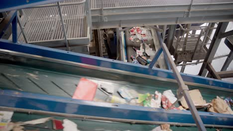 cinta transportadora con materiales de desecho, papel y plástico que transfiere los residuos a un sitio designado de eliminación o procesamiento