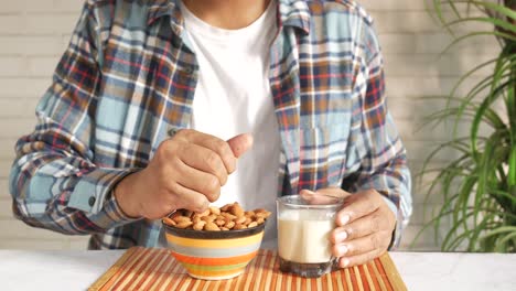 man enjoying almonds and almond milk