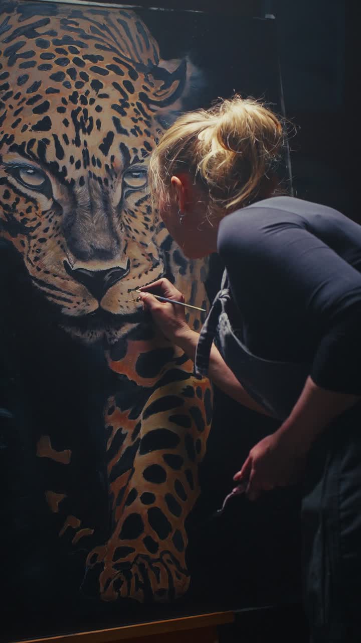 Artist painting a leopard portrait in studio