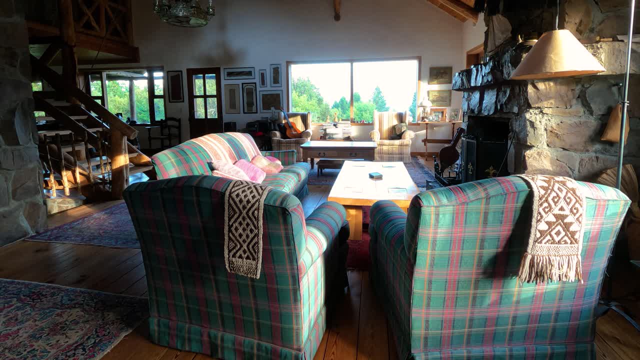 Empty living room with table and old couch and armchair inside ancient cottage during sunlight outdoors. Time lapse shot.